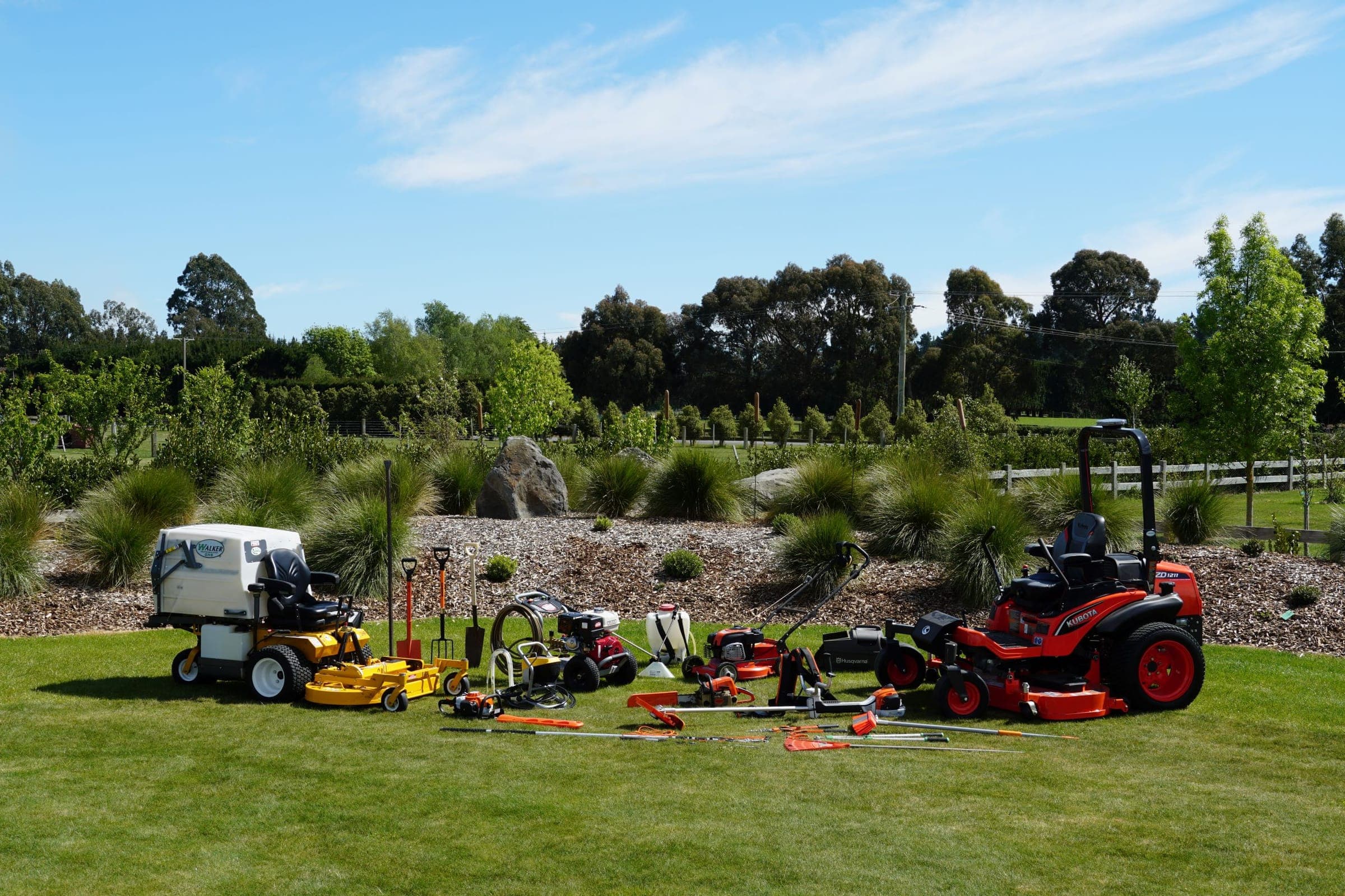 Greentek's mowers, sprayers and garden tools lined up on a lawn